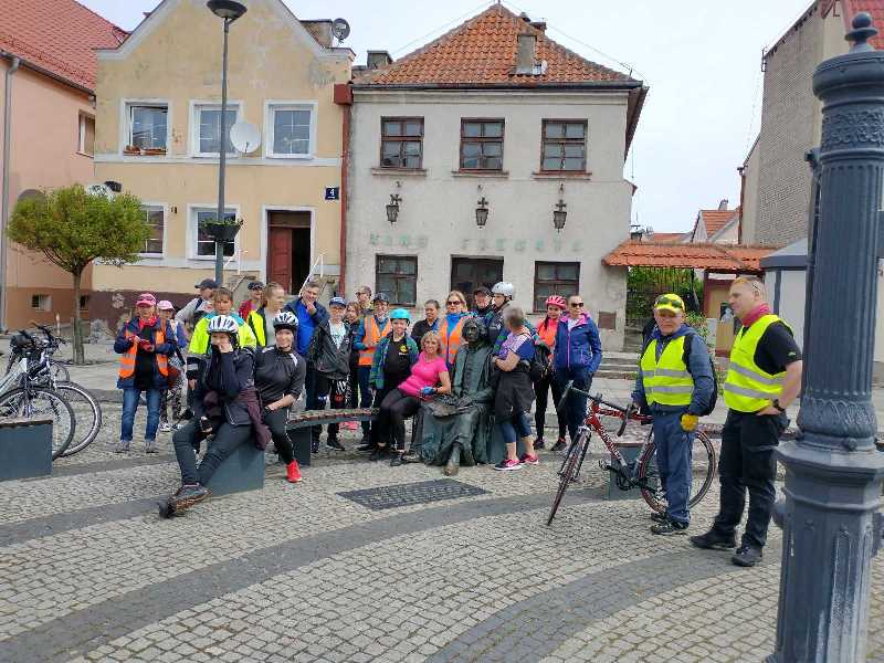 Na zdjęciu znajdują się uczestnicy IX rajdu rowerowego "Odjazdowy Bibliotekarz". Zdjęcie zrobiono na fromborskim rynku przy pomniku Mikołaja Kopernika. 